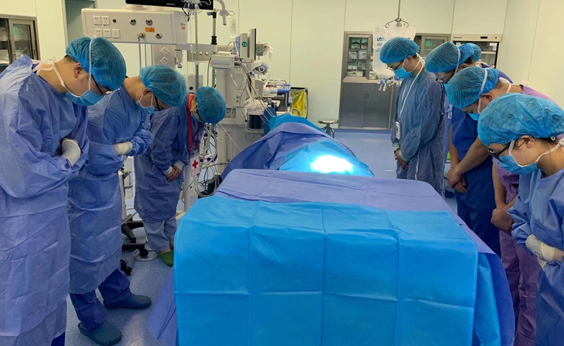 手术室内，医生及相关工作人员向躺在手术台上的杨丰瑞深鞠一躬。受访者供图