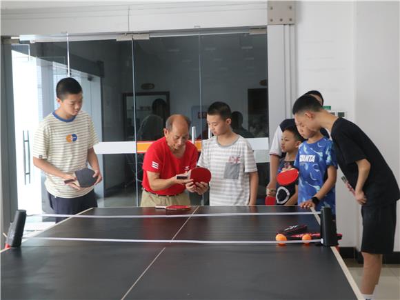 乒乓球老师手把手教孩子们学习握拍姿势。通讯员 蒋平 摄
