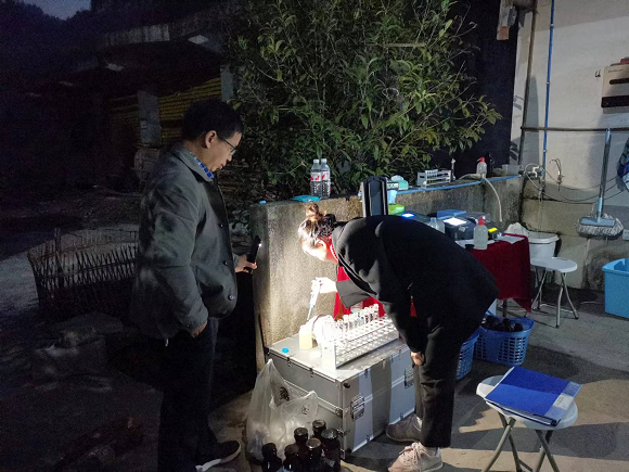 彭水监测人在黔江白石镇天翼牧业污水外泄事件现场实验室分析样品。通讯员 李强 摄