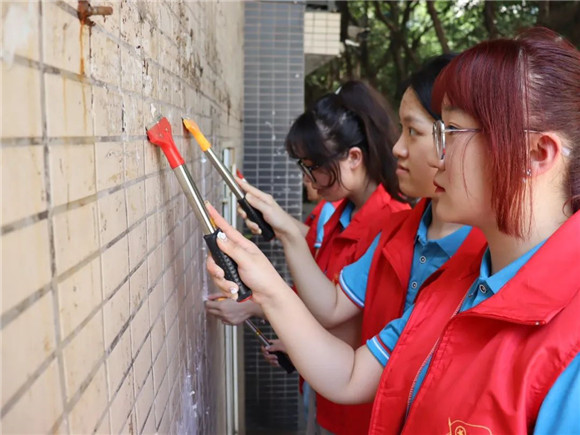 四川外国语大学志愿者清理小广告。九龙坡区团区委供图 华龙网发