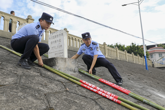 永川区公安局大安派出所在辖区的危险水域投放溺水救援竹竿。永川区委宣传部供图 华龙网发