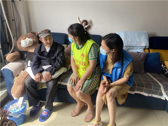 2志愿者正在关心刘学盛老人的身体情况。龙山街道供图