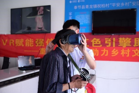 志愿者为老人佩戴VR设备