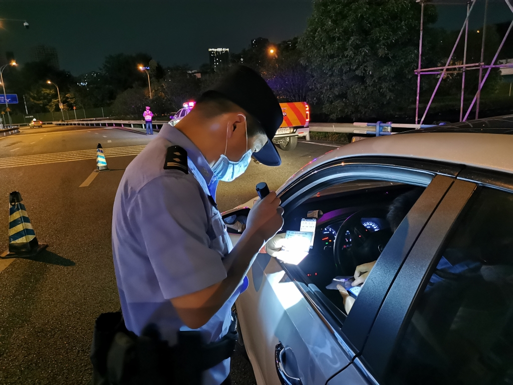 2民警检查酒后驾车及管制刀具等危险物品。沙坪坝区警方供图