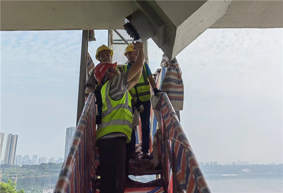 设施维护管理者对马桑溪大桥拉索下锚头进行开锚清理，并更换锚头黄油。重庆市市政设施运行保障中心供图 华龙网发