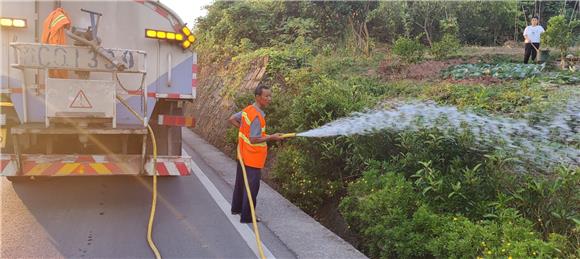 1大足公路养护中心工人为辖区公路沿线花草浇水解渴。特约通讯员 蒋文友 摄
