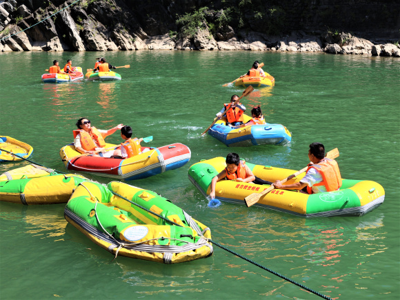 图四：游客们乘坐着皮划艇，享受着夏日的清凉。湛江涛，摄