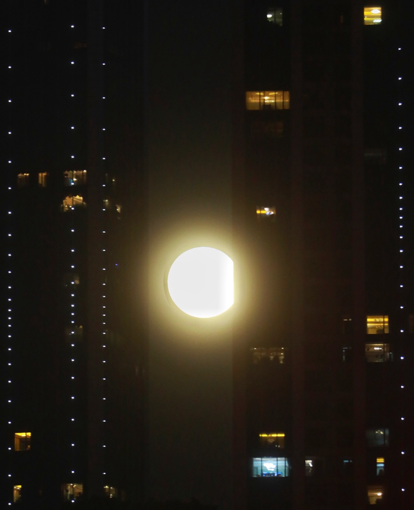 圆月在城市楼宇间“穿行”。华龙网-新重庆客户端记者 张质 摄