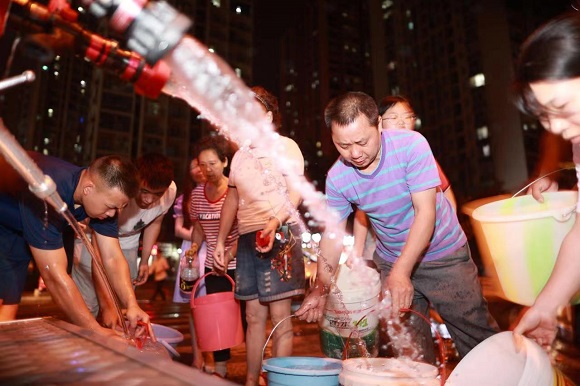 当地应急队员为居民送水。重庆市应急管理局供图
