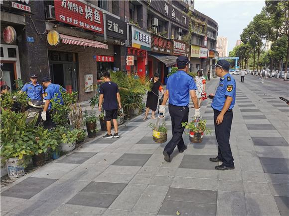 龙山街道交巡警、城管人员正在对占道经营商户进行文明劝阻。通讯员 陈天红 摄