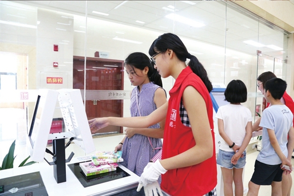 渝北区图书馆志愿者为读者提供引导服务。渝北区文化旅游委供图 华龙网发