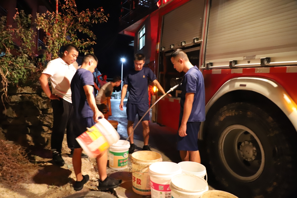 1秀山县消防员为群众送水。受访者供图