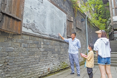 5市民倾听社区规划师张真飞讲解七星岗的历史。记者 王欢 摄