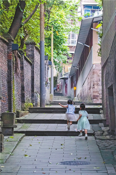 孩童在通遠門旁的巷子里奔跑，留下一路歡笑。渝中報記者 王歡 攝