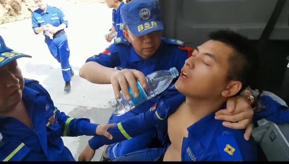 蓝天救援队员姚裕连续奋战12小时，体力透支晕倒。重庆市蓝天救援队供图