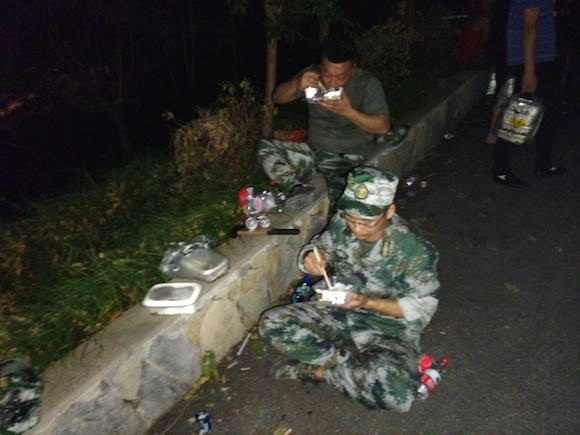 铃耀汽车参与救火的民兵队员，饿了就地坐下吃饭。受访人供图