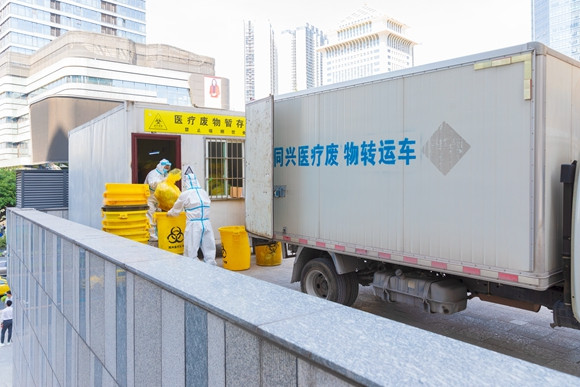 8月21日，铁山青年干部突击队队员在江北区一酒店隔离点转运医疗废物。林豪 摄