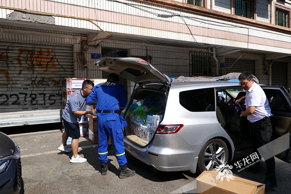 工作人员把捐赠物品搬下车。华龙网-新重庆客户端记者尹建红摄
