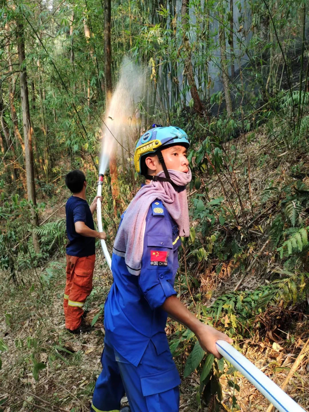 刘艺（右）协助消防官兵参与一线灭火。受访者供图