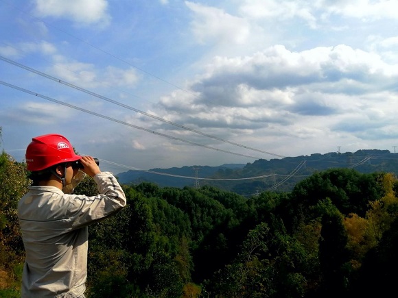 國網綦江供電公司工作人員利用望遠鏡觀察500千伏線路狀況。通訊員 鄢江奎 攝