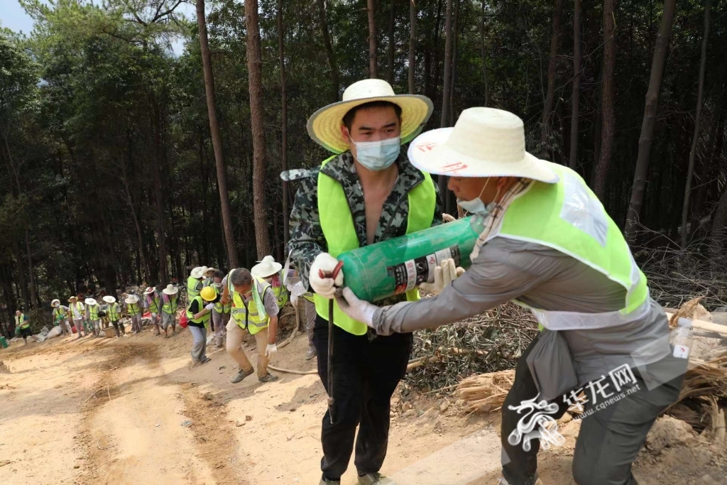 志愿者將救援物資傳遞到山頂。華龍網-新重慶客戶端記者 李文科 攝