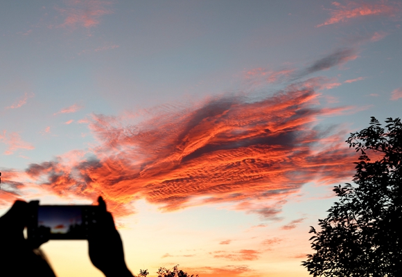 一位准备夜游八达岭长城的游客拍摄落日彩云。