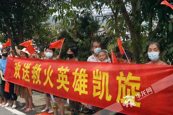 村民们拉着横幅欢送云南森林消防官兵返程。华龙网-新重庆客户端记者 欧武夷 摄
