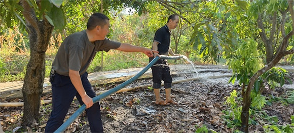 刘家奇巡查果树灌溉情况，并指导村民合理灌溉。夏林 摄