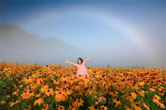 游客在红池坝景区与彩虹、鲜花合影。李定平 摄