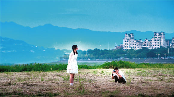 汉丰湖畔，游客们正在打卡留念。开州日报记者 王晓宇 摄
