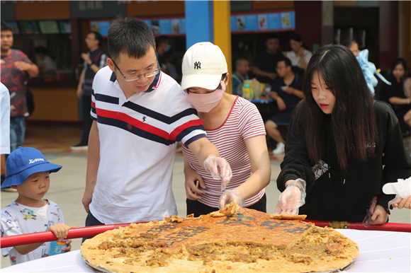 游客品尝“巨无霸”月饼。通讯员 杨孝永 摄