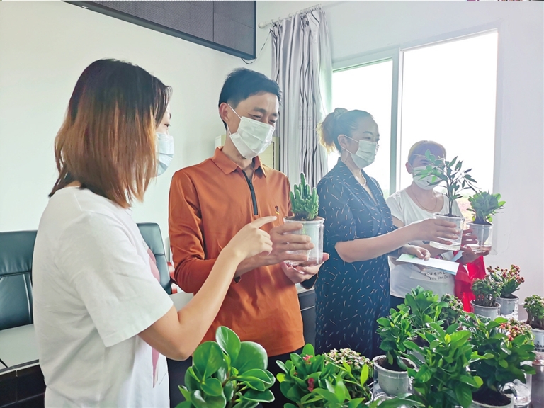 志愿者现场向群众赠送绿植。记者 杨荟琳 摄