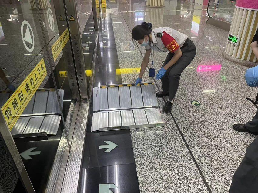A safety staff laying an accessible board. (Photo provided by Chongqing Rail Transit Group)