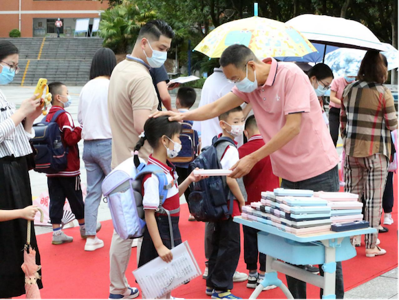 Mou Jun, the school master of Renhe Experimental School, was distributing the school-opening gifts to welcome the new arrivals. (Photographed by Hou Mingming)