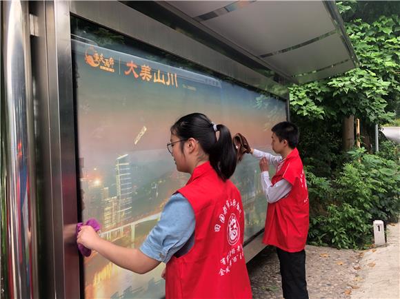 虎峰村青年志愿者正在打扫车站站牌。通讯员 吕利 摄