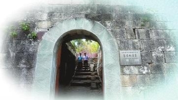 4游客行走在观音寨古朴的寨门下。记者 向成国 摄