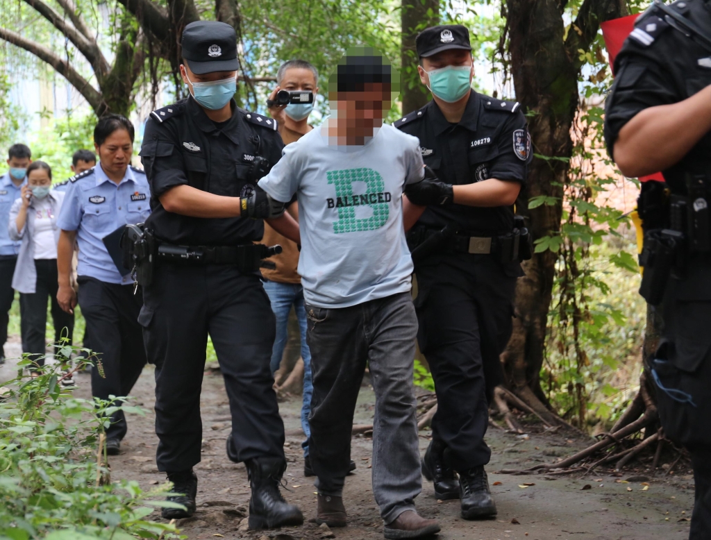 2民警押解嫌疑人进山辨认。重庆九龙坡警方供图