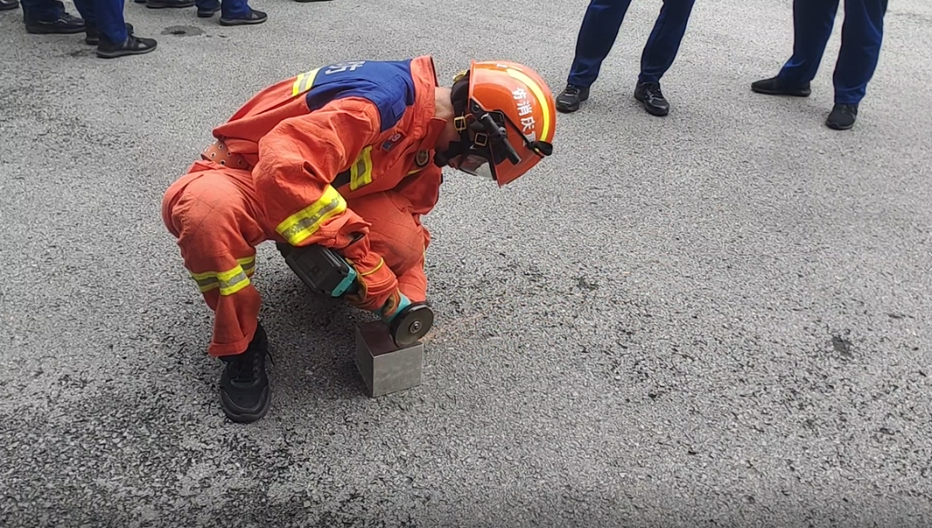 3消防员使用砂轮机切开不锈钢盒子。重庆大足消防供图