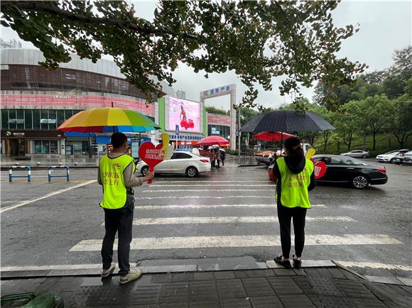 2志愿者正在开展交通路口劝导工作。通讯员 尹欢欢 摄