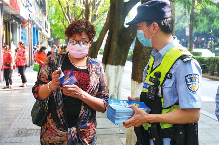 民警向居民发放防诈骗宣传资料。记者 王彦雪 摄