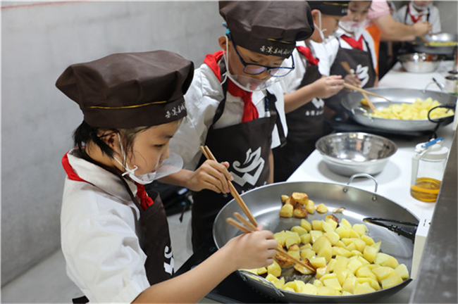 学生正在厨艺坊制作巫溪锅巴洋芋。城厢小学供图 华龙网发