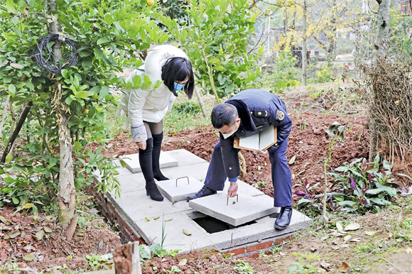 工作人员检查验收修建好的化粪池。记者 刘亚春 摄