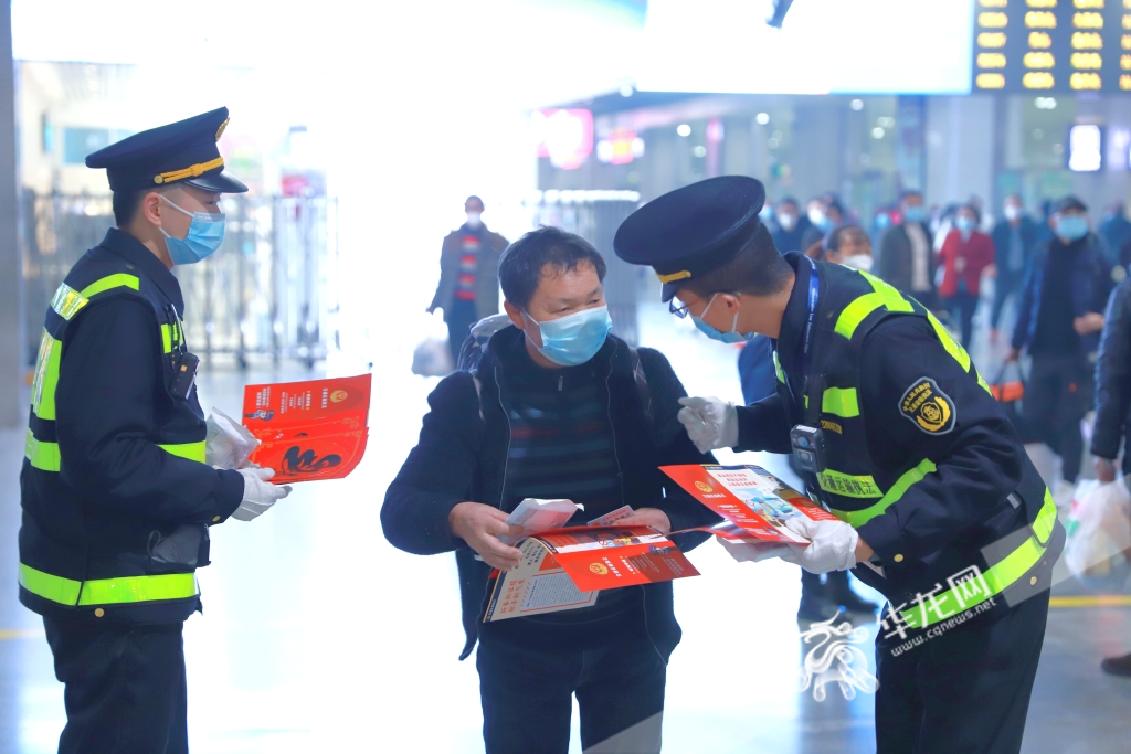 交通执法人员在重庆北站北广场，向旅客宣传交通安全常识，送上装有福字和口罩的礼包。华龙网-新重庆客户端记者 尹建红 摄