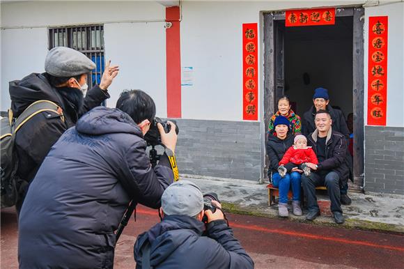 摄影志愿者正在为村民免费拍摄全家福。特约通讯员 陈星宇 摄