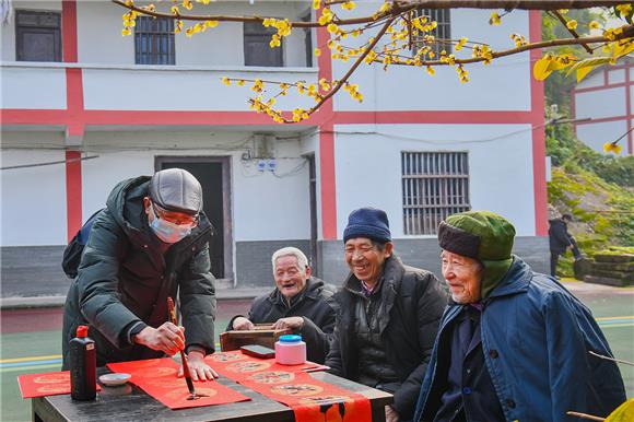 摄影志愿者为村民书写春联。特约通讯员 陈星宇 摄