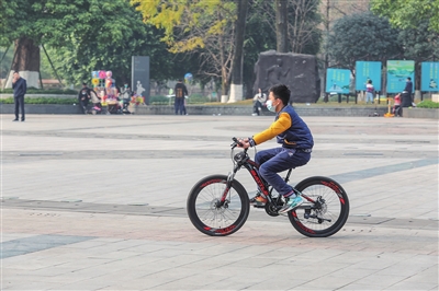 1少年在广场上畅快地骑着单车。记者 曹检 摄