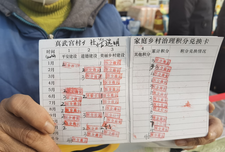 村民展示积分手册。记者 邬姜 摄