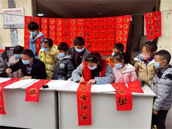 孩子们观看志愿者写春联。记者 刘柳吟 吴明鸽 供图