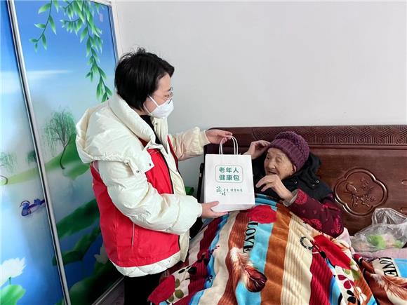 暖心小分队工作人员为老人送上暖心“健康包”。通讯员 周小琪 摄