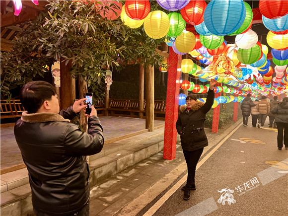 游客在花灯长廊前拍照留念。华龙网-新重庆客户端记者 曹建 摄